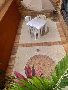 een tafel en stoelen en een parasol op een patio bij Tu hogar en la mitad del mundo. in Quito