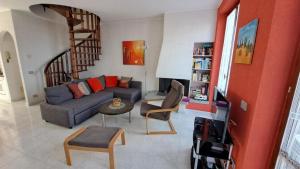 sala de estar con sofá y escalera de caracol en Residenza Nasca mit Schwimmbad, en Castelveccana