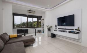 een woonkamer met een bank en een flatscreen-tv bij The Views BNB in Durban