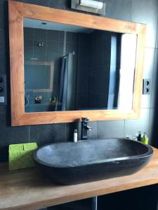 y baño con lavabo negro grande y espejo. en Ferienhaus für 8 Personen ca 300 qm in Couvin, Wallonie Provinz Namur, en Couvin