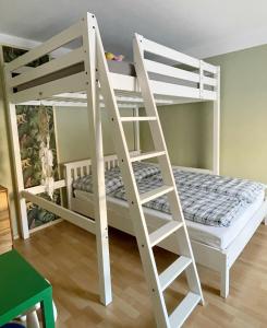 ルッケンヴァルデにあるFeWo Jack's Worldの白い二段ベッド(はしご付)が備わる客室です。