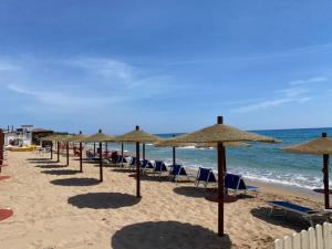 uma fila de guarda-sóis e cadeiras numa praia em Makauda Beach em Sciacca