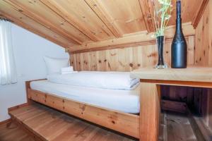 ein Bett in einer Holzhütte mit einer Vase in der Unterkunft Casa La Roda Nr 3 in Sedrun