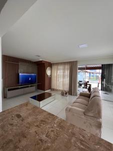 uma sala de estar com um sofá e uma televisão de ecrã plano em Casa, Frente Mar, Vera Cruz, Ilha de Itaparica, Tairu! em Vera Cruz de Itaparica