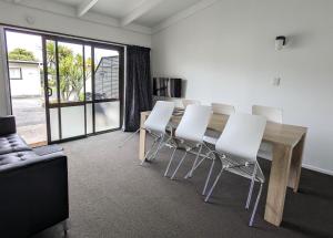 a dining room with a table and white chairs at Holdens Bay Holiday Park in Rotorua