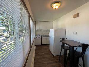 uma cozinha com uma mesa e um frigorífico branco em Liberty Valley Short Term Rental - 29 em Madison