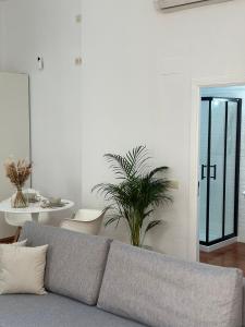 a living room with a couch and a plant at Suite Alameda in Seville