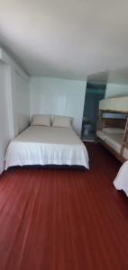1 dormitorio con 1 cama y suelo de madera en Alojamiento playa blanca Barú. InHousecaribe, en Playa Blanca