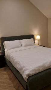 a large bed in a bedroom with a white bedsheet at Attic Room in Citywest in Dublin