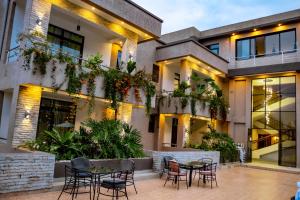 a courtyard with tables and chairs in front of a building at Grazia Apartment Hotel in Kigali