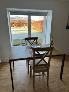 a table with two chairs and a bottle of wine at Fairness Cottage, Near Comrie in Comrie