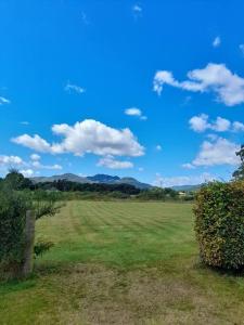 a field with green grass and a blue sky with clouds at Fairness Cottage, Near Comrie in Comrie