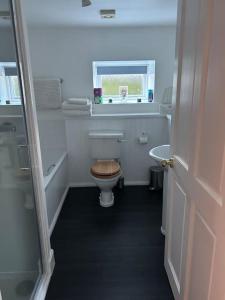 a bathroom with a toilet and a tub and a sink at Fairness Cottage, Near Comrie in Comrie