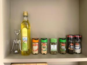a shelf with a bottle and jars of spices at HNFC Stays - Corporate Central Studios + Parking in Newcastle upon Tyne