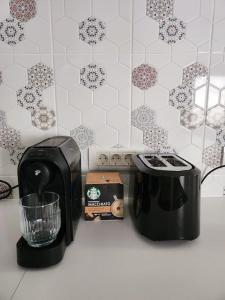 a kitchen counter with a coffee maker and a toaster at Cozy house Elena in Drăgoiasa