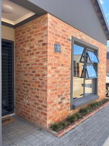 a brick wall with a window and a sign on it at Home@Micasa in Potchefstroom