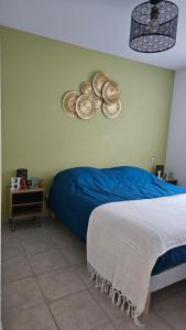 1 dormitorio con 1 cama y 2 sombreros en la pared en Bel appartement F3 tout confort, en Saint-Vincent-de-Paul