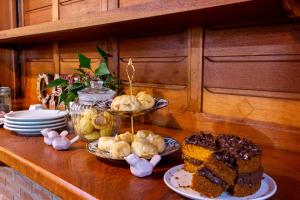 uma mesa coberta com pratos de comida e sobremesas em Pousada Suiça Mineira Garden em Monte Verde