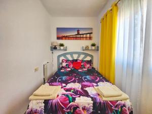 um quarto com uma cama com uma colcha colorida em Mallorca 3 em Playa de Gandia