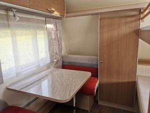 Familienwohnwagen im Emmental : مطبخ صغير مع طاولة في القافلة