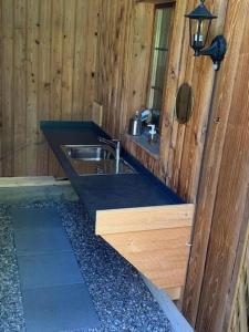 a bathroom with a sink in a wooden cabin at Familienwohnwagen im Emmental 