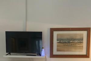 un televisor sentado en un estante junto a una foto en Casa Elisa, en Bellaria-Igea Marina