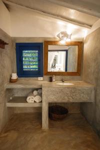 a bathroom with a sink and a mirror at Pousada Lagoa in Caraíva +84 photos