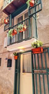a house with a door and a balcony with potted plants at Maison Zazà Naples in Naples