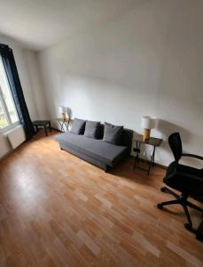 ein Wohnzimmer mit einem Sofa und 2 Stühlen in der Unterkunft Très beau 2 pièces à 400m de Paris in Gentilly