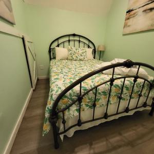 a bedroom with a black bed with a floral bedspread at Fern Gully cabin in Conway