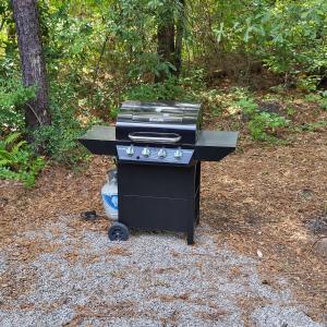 a black barbecue grill sitting on the ground at Fern Gully cabin in Conway