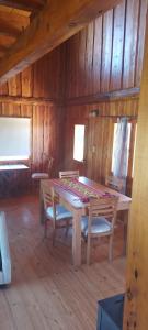 ein hölzernes Esszimmer mit einem Tisch und Stühlen in der Unterkunft La Pancora del Futa in Los Cipreses