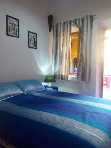 a bedroom with a large bed with a blue blanket at Riad Le Lieu in Tiznit