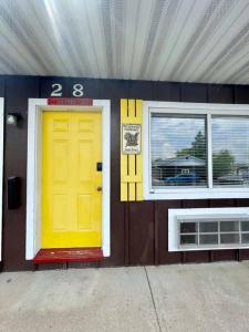 a building with a yellow door and two windows at #28 Snooze in Wisconsin Rapids