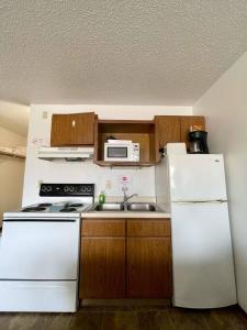 una pequeña cocina con electrodomésticos blancos y armarios de madera. en #28 Snooze, en Wisconsin Rapids