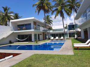 a large house with a swimming pool in front of it at Luxury Palms Puerto Arista in Puerto Arista