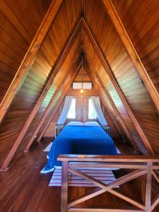 um quarto num sótão de madeira com uma cama em Villa Park Chalés - A sua fazendinha ao lado do Beto Carrero em Penha