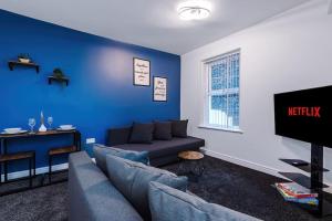 ein Wohnzimmer mit einem Sofa und einem TV in der Unterkunft Spacious modern apartment in central location - free parking in Liverpool