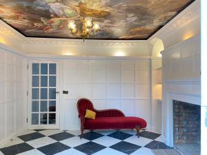 a living room with a red couch and a painting on the ceiling at Royal Windsor Country Estate Private 5 Acres of Gardens in Windsor