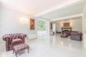 a living room with leather furniture and a fireplace at Royal Windsor Country Estate Private 5 Acres of Gardens in Windsor