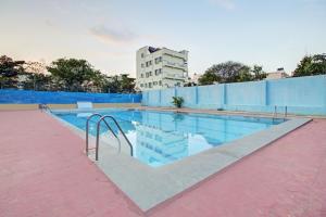 a swimming pool with a building in the background at Super OYO RK Club House in Kammasandra