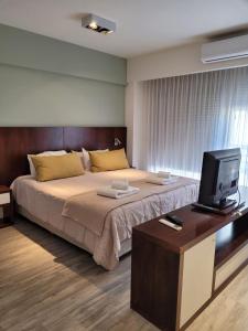 ein Schlafzimmer mit einem großen Bett und einem Fernseher in der Unterkunft Color Botánico in Buenos Aires