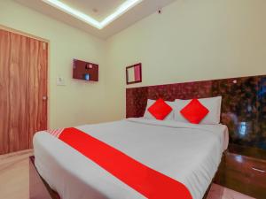 een slaapkamer met een groot bed met rode kussens bij OYO Hotel Apoorva in Shamshabad