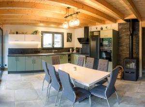 a kitchen with a table and chairs in a room at Chalet cosy 4 étoiles le Domaine Des Mésanges in Plainfaing