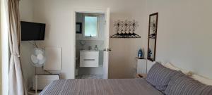 a bedroom with a bed and a sink and a mirror at 15 On Wards in Greytown