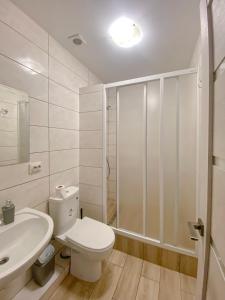 een badkamer met een toilet, een wastafel en een douche bij Апартаменты in Vinnytsya