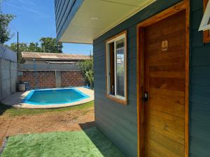 uma casa com uma porta e uma piscina em Alojamiento Rústico Belloto 4 em Quilpué