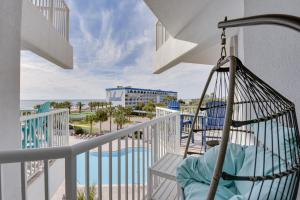 a swing on a balcony with a view of the beach at Sunny Fort Walton Beach Condo - Walk to Ocean! in Fort Walton Beach