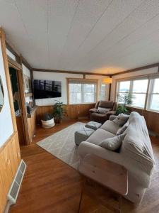 - un salon avec un canapé et une télévision dans l'établissement Waters Edge Cottage, à Merrimac
