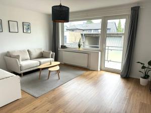 a living room with a couch and a table at Moderne 2 Zimmer Wohnung (52qm) am CentrO! in Oberhausen